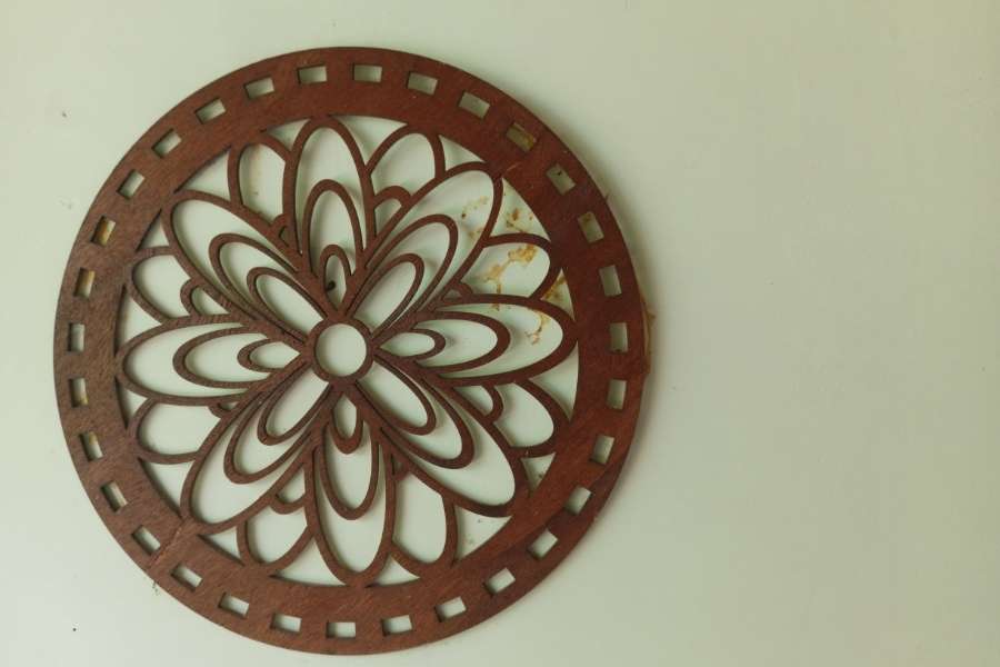 Un objet circulaire en bois sculpté de motifs floraux pour décorer les murs avec élégance.